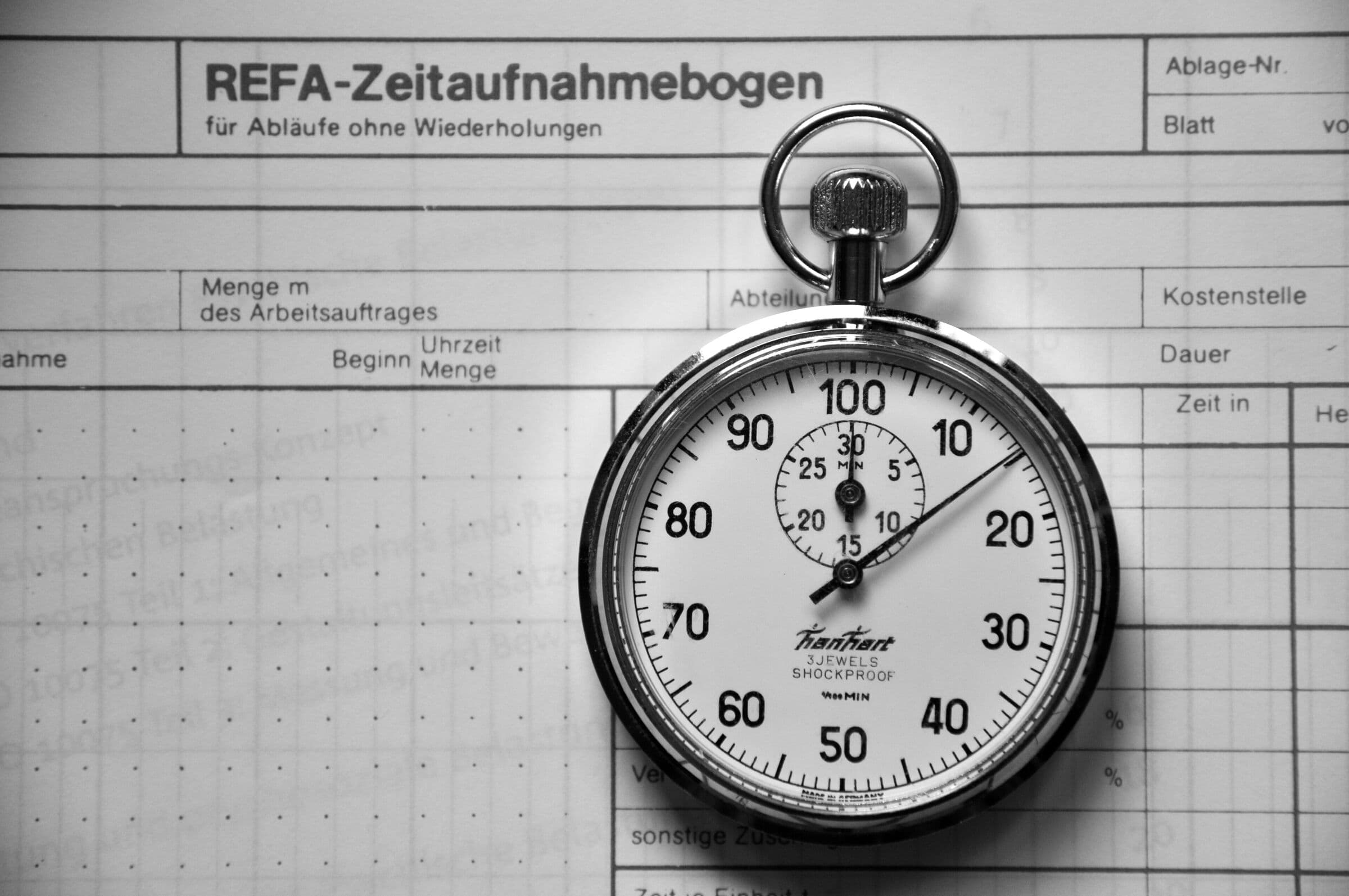 Analoge Stoppuhr auf einem Zeitaufnahmebogen, schwarzweiß